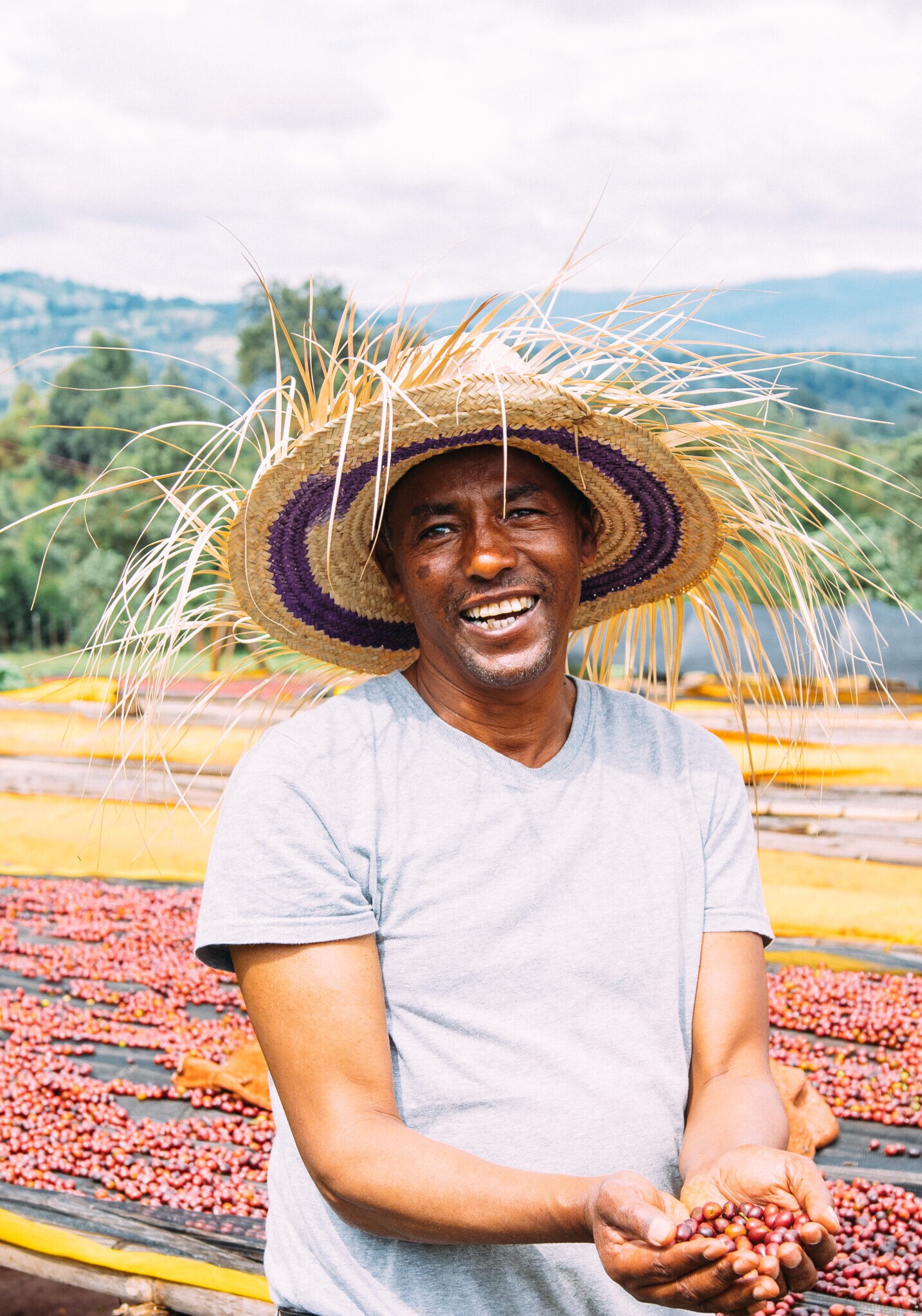 Kaffeebauer lächelt an einer Trockenstation in Äthiopien, Teil der Beschaffung von PASSENGER Coffee.