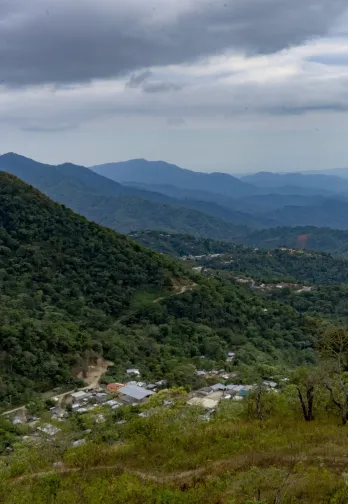Bergige Landschaft mit Kaffeeanbau und einem Dorf im Tal